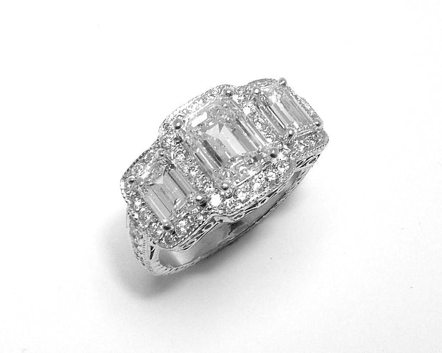 Platinum Three Stone Emerald Cut Ring with Round Diamond Halo