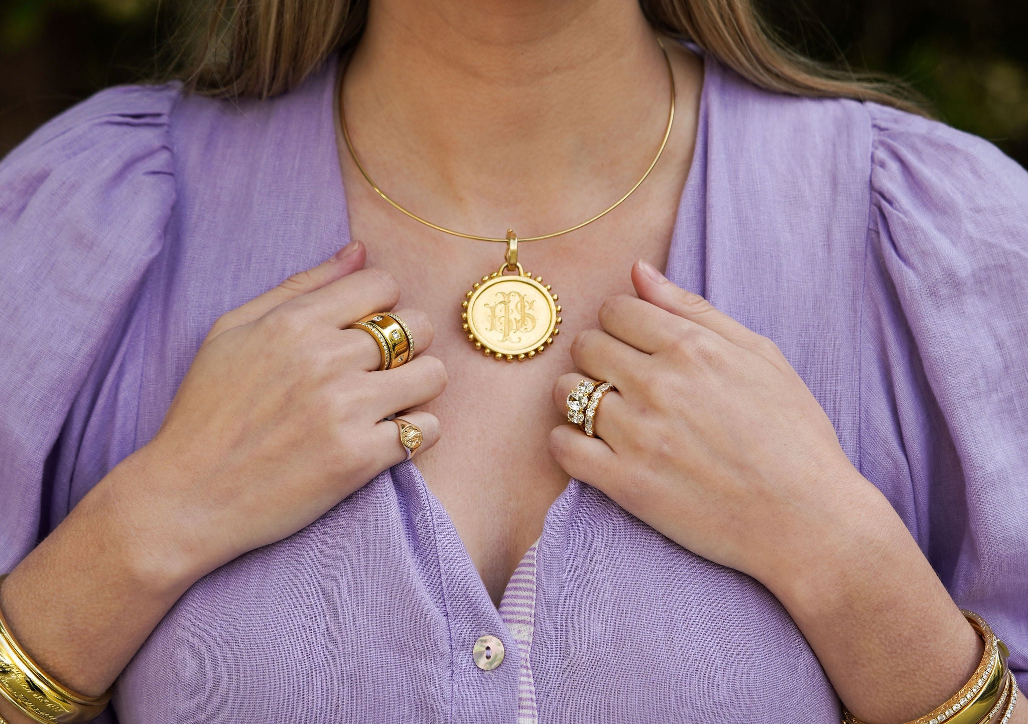 woman wearing engraved gold pendant on necklace