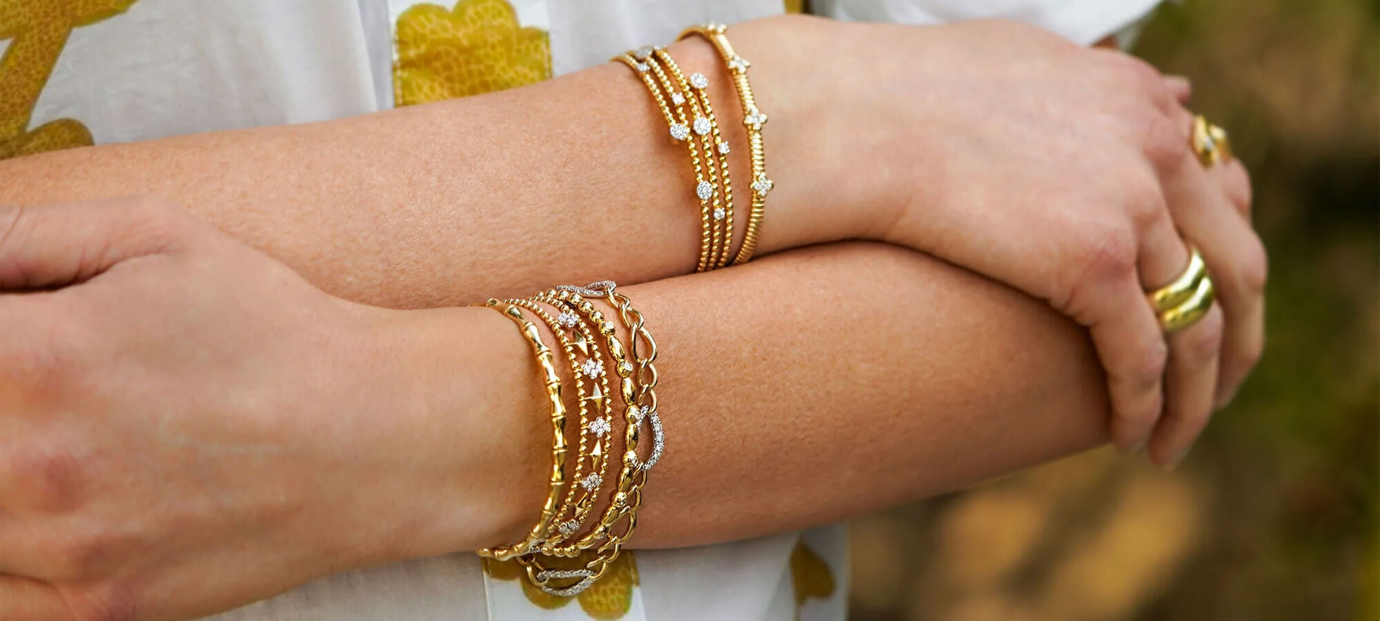 woman wearing 18k yellow gold bracelets curated by Laura Pearce