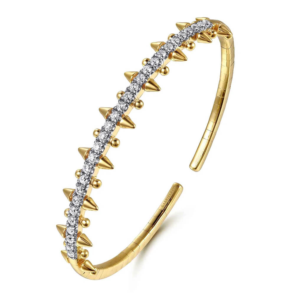 A 14K yellow gold cuff bracelet featuring a central row of clear pavé-set diamonds and multiple pointed spike accents on both sides, shown on a plain white background.