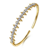 A 14K yellow gold cuff bracelet featuring a central row of clear pavé-set diamonds and multiple pointed spike accents on both sides, shown on a plain white background.