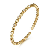 A 14K gold beaded cuff bracelet with alternating smooth oval beads and small round bezel-set clear diamonds, shown on a clean white background.