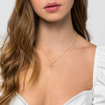 yellow gold diamond cross pendant necklace on model neck
