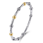 A two-tone metal beaded bracelet with sterling silver and 14K yellow gold beads shown on a clean white background.