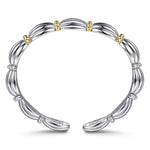 A sterling silver bangle bracelet with a segmented, ribbed design and small 14K gold bead accents, shown on a clean white background.