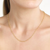 A close-up of a model's neck and upper chest wearing a delicate 14K yellow gold chain hollow oval link necklace.