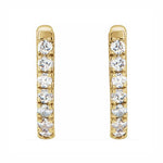 A pair of 14K gold huggie hoop earrings with diamonds