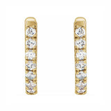 A pair of 14K gold huggie hoop earrings with diamonds