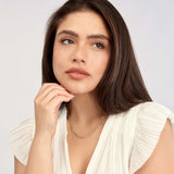 Woman wearing a 14K gold link necklace against a light gray background