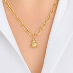 A gold chain necklace with a 14K gold beetle pendant, worn on a model's neck over a white collared shirt.