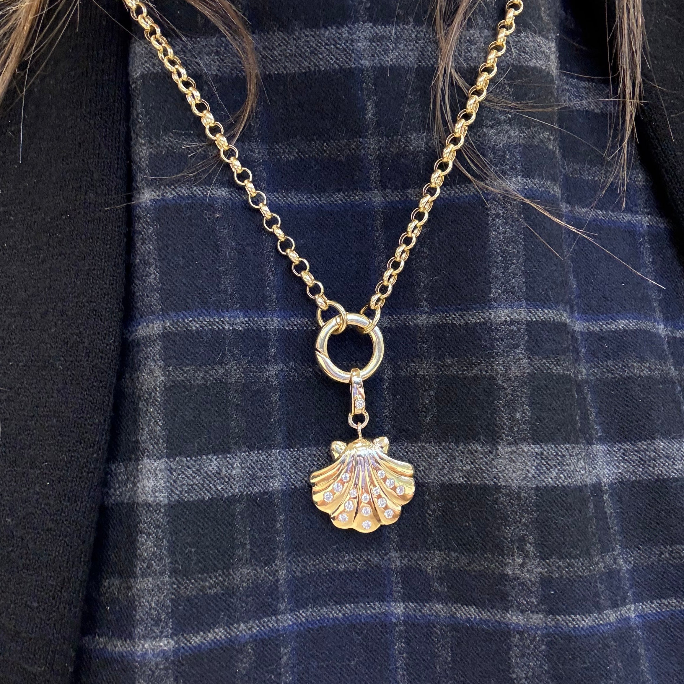 14K Gold necklace with a shell pendant on a blue plaid fabric background