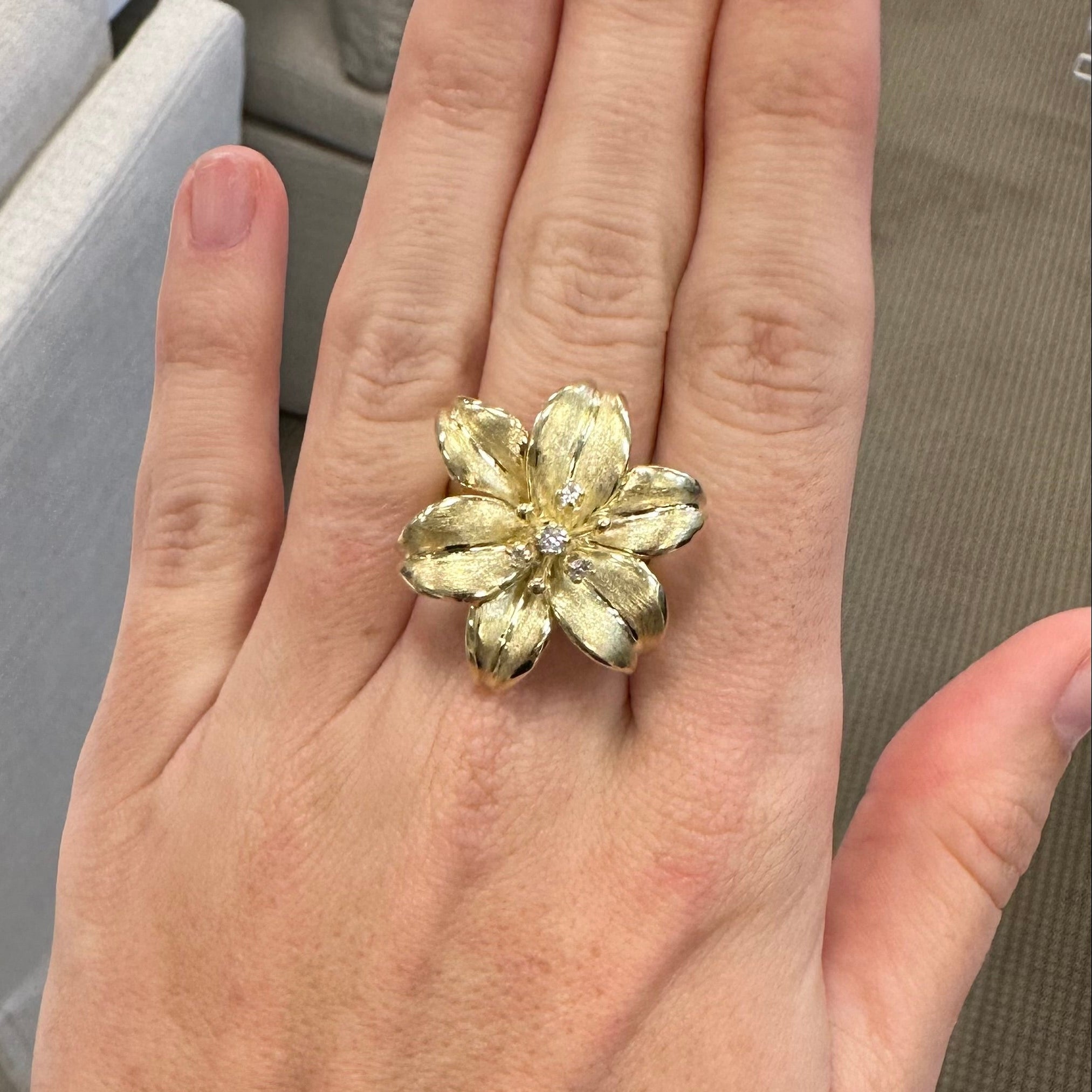 woman wearing 14K gold flower ring with diamonds