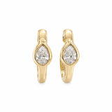 A pair of 14K gold huggie hoop earrings with pear-cut clear diamonds in the center, shown on a plain white background.