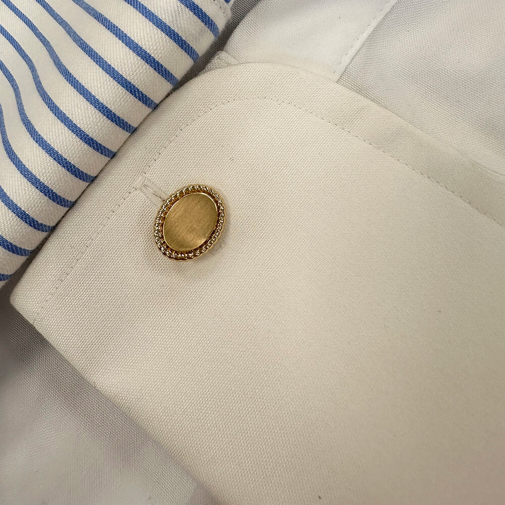 Close-up of a 14k gold oval rope edge cufflink on a shirt
