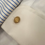 Close-up of a 14k gold oval rope edge cufflink on a shirt