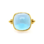 A 14K yellow gold ring with a large blue topaz centerpiece.