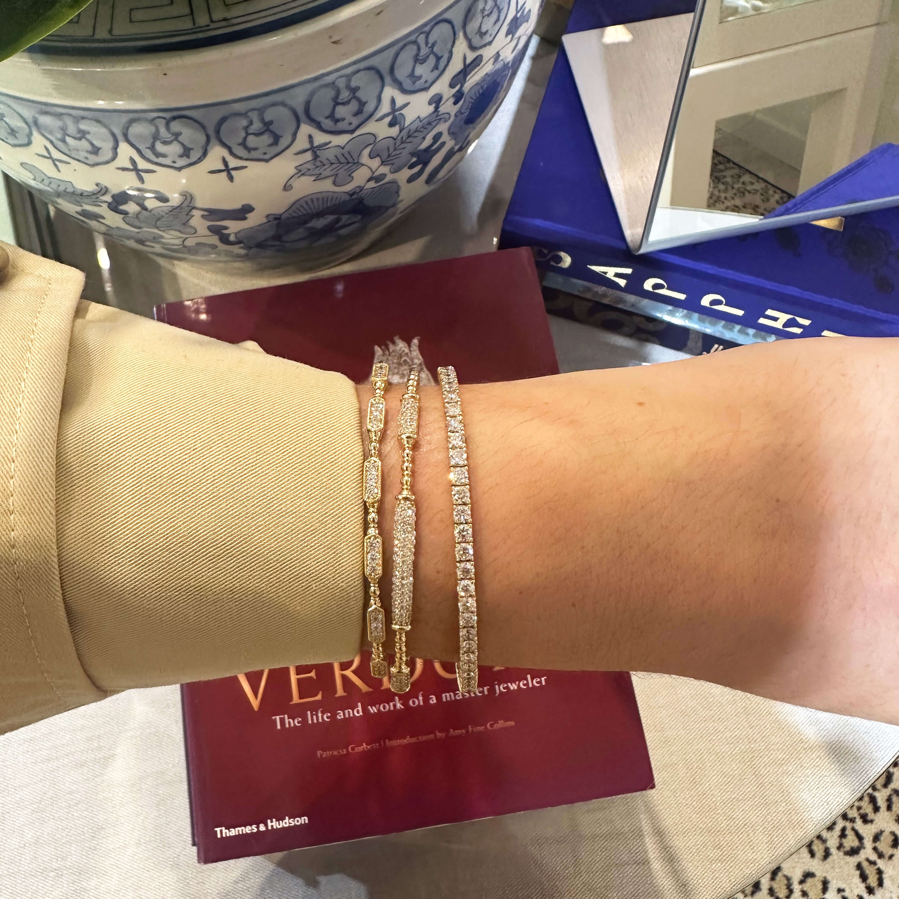 Woman wearing several gold and diamond bracelets offered at Laura Pearce