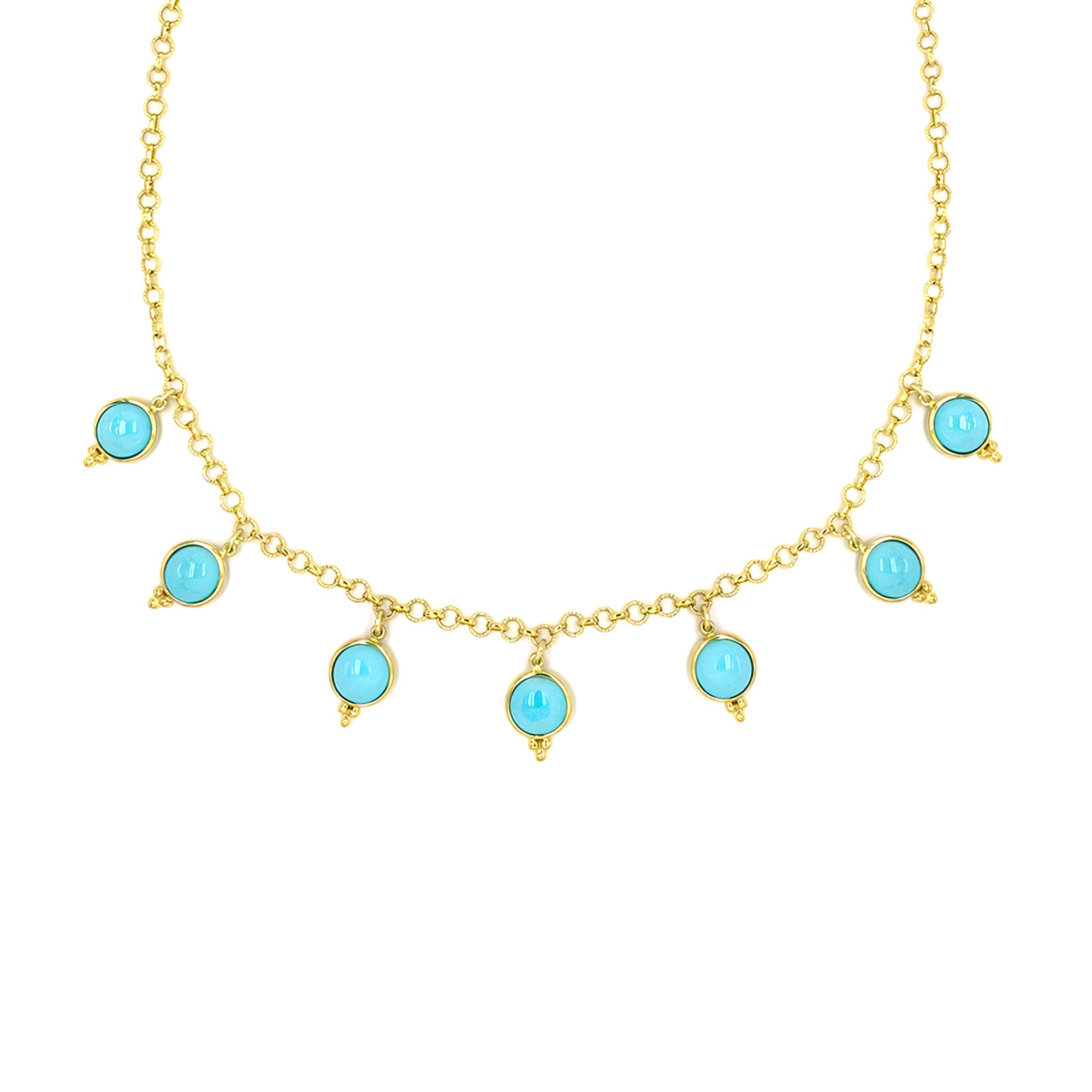 Gold necklace with turquoise stones on a white background
