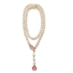 Pearl necklace with pink gemstone drop stones on a white background