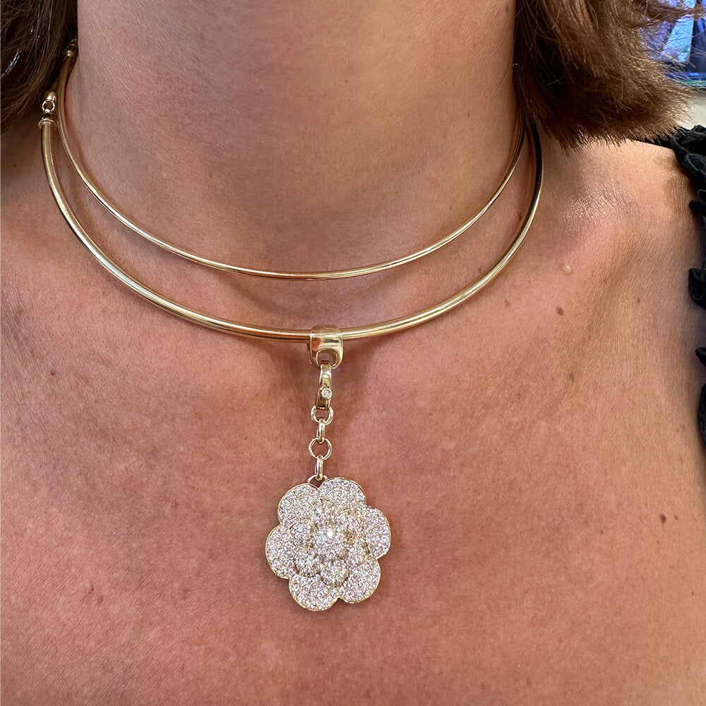 Close-up of a woman wearing a 14K gold choker necklace with a diamond floral pendant.