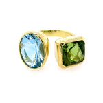 A 14K yellow gold ring with a bezel set featuring one large blue aquamarine oval stone and one large green peridot square stone.