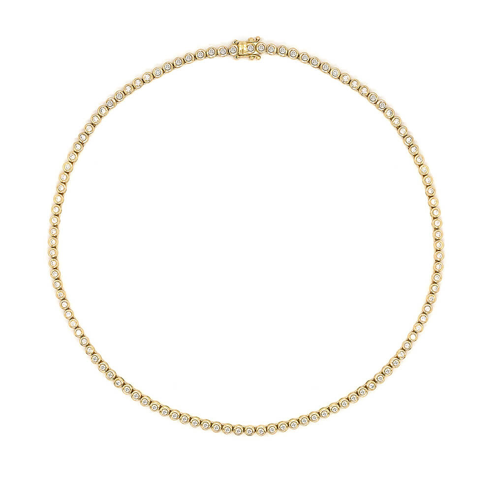 A 14K yellow gold tennis necklace with a small repeating row of clear diamonds all around, shown on a plain white background.