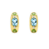A pair of 14K yellow gold earrings featuring blue topaz centers with peridot accents and diamond accents