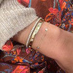 Close-up of a wrist wearing several gold  and diamond bracelets 