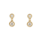 A pair of 14k yellow gold diamond bezel drop earrings.