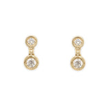 A pair of 14k yellow gold diamond bezel drop earrings.