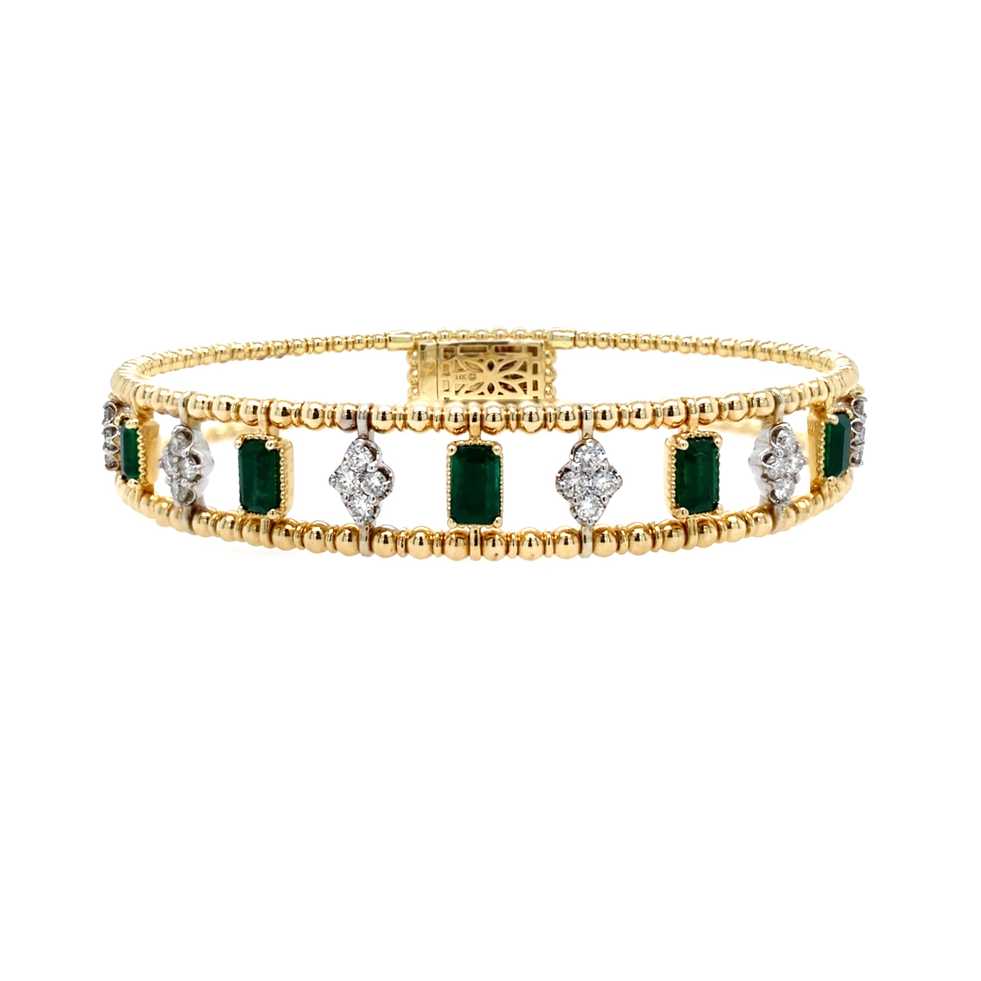 Gold bracelet with emeralds and diamonds on a white background