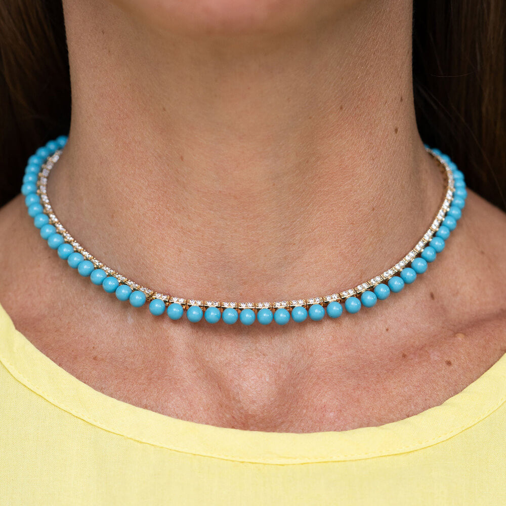 Turquoise beaded necklace with diamonds worn by a woman with a yellow shirt