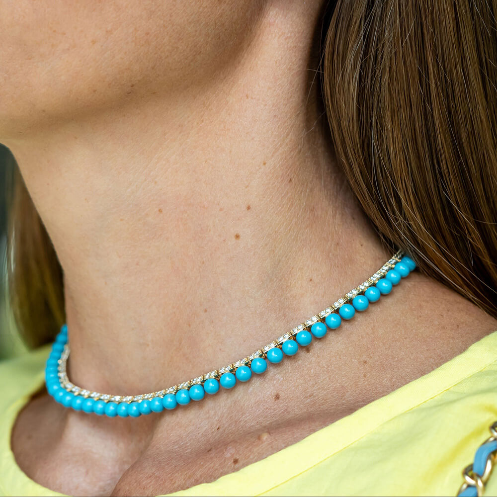 Close up of a woman wearing a Turquoise beaded necklace with diamonds