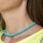 Close up of a woman wearing a Turquoise beaded necklace with diamonds