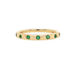 14K Gold ring with emerald stones on a white background