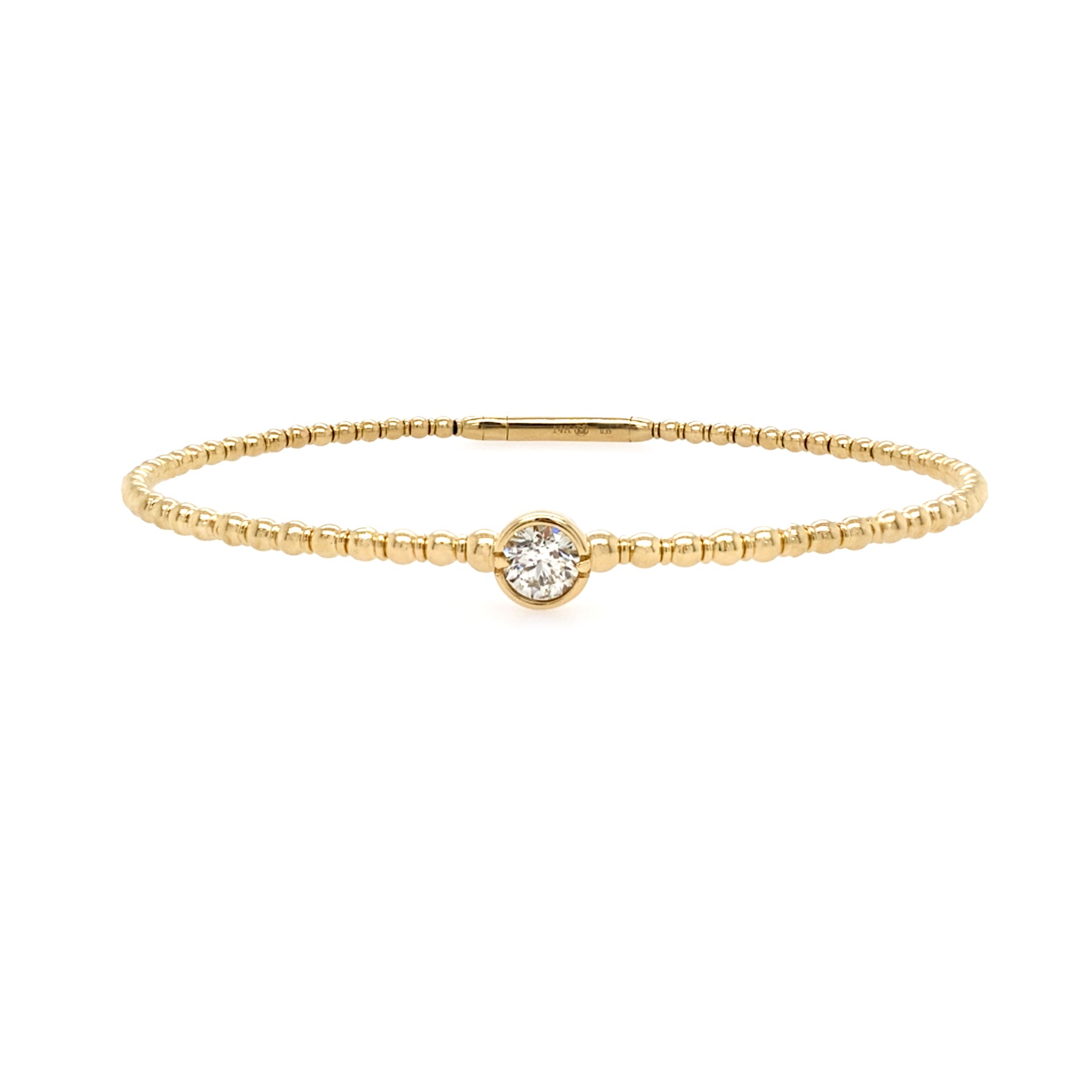 A 14K yellow gold bangle bracelet with a single diamond centerpiece, set on a white background.