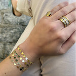 Woman wearing heart-shaped bracelets and gold rings 