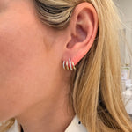 Close-up of an ear wearing gold hoop and diamond earrings 