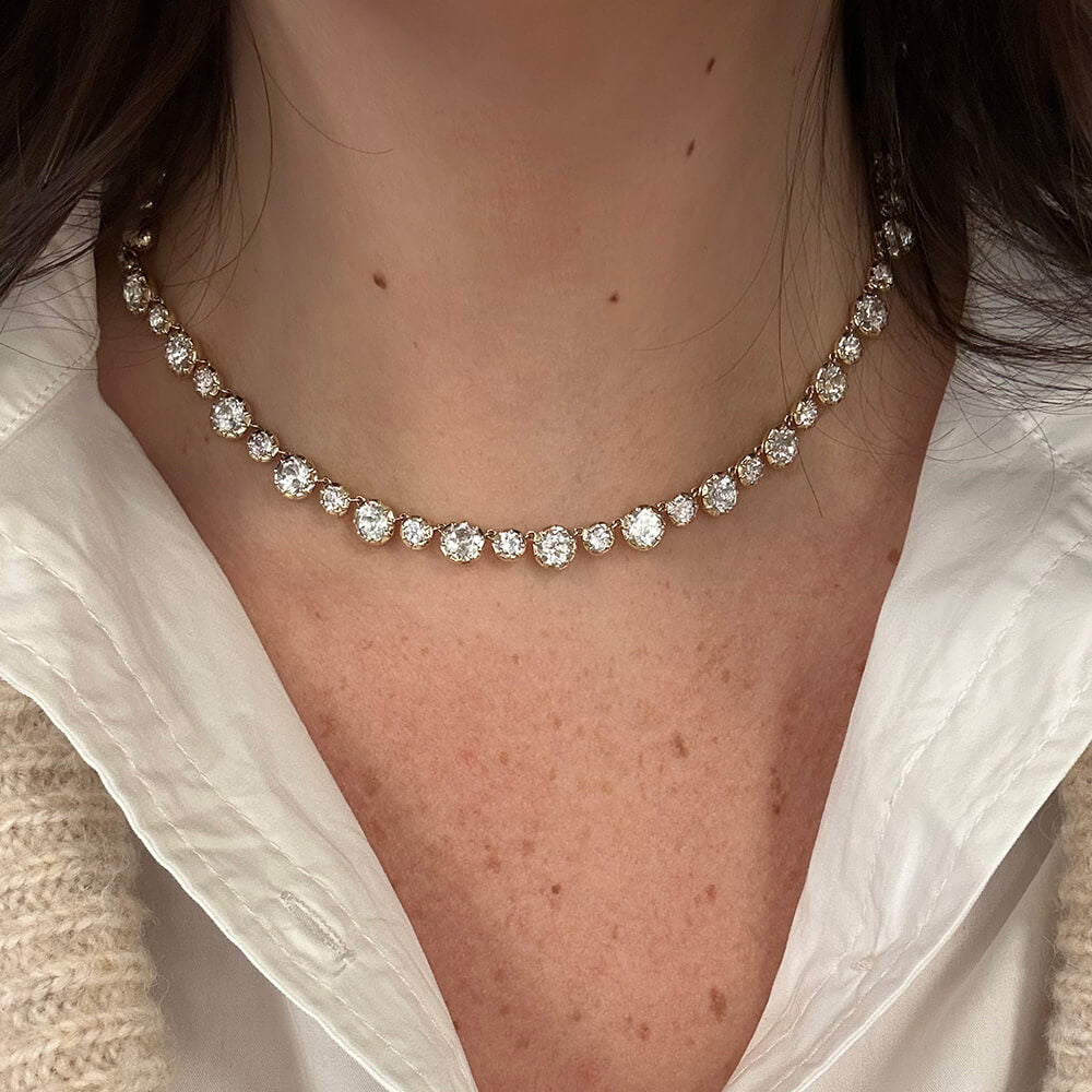 Close-up of a woman wearing a 14K gold necklace with White Topaz stones 