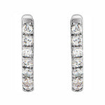 A pair of 14K white gold huggie hoop earrings with diamonds