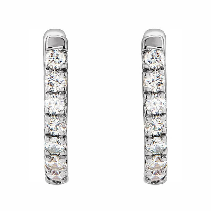 A pair of 14K white gold huggie hoop earrings with diamonds
