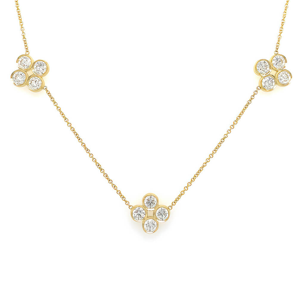 An 18K yellow gold necklace featuring 3 diamond encrusted clover stations.