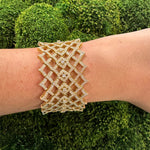 18K Gold lattice-design bracelet with diamonds on a wrist 