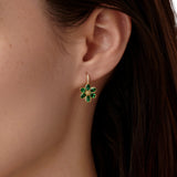 Close-up of a woman wearing a green tsavorite earring with diamonds in 18K gold designed by Elizabeth Locke