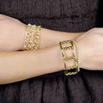18K yellow gold bangle stacked with diamond bracelets on a wrist