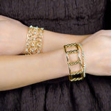 18K yellow gold bangle stacked with diamond bracelets on a wrist