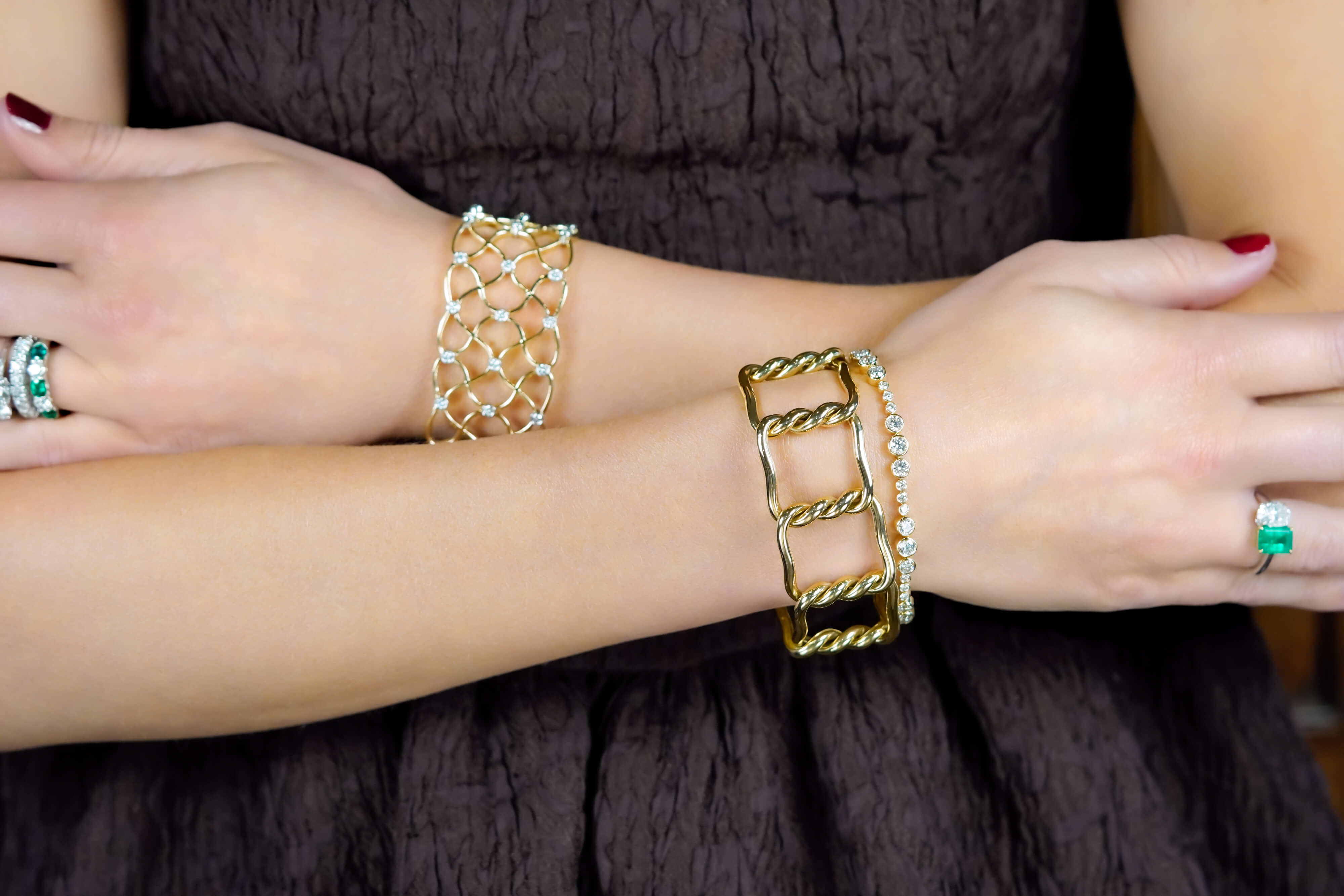 18K yellow gold bangle stacked with diamond bracelets on a wrist