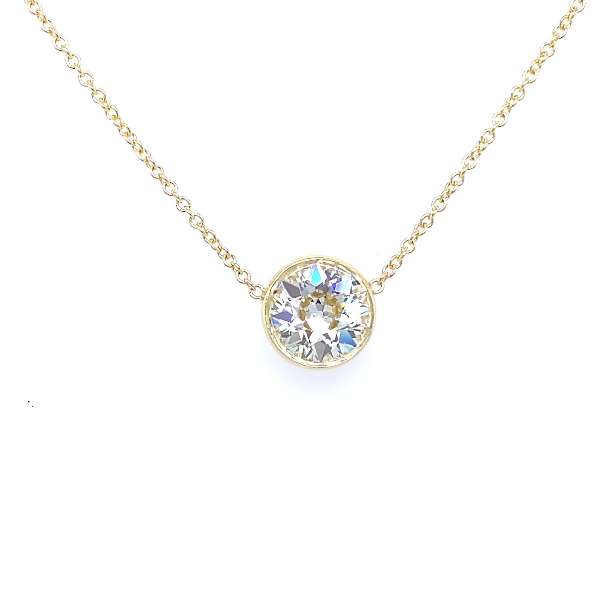 An 18kt yellow gold bezel set diamond pendant on a white background.