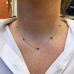 Woman wearing 18K yellow gold Sapphire 5 station necklace