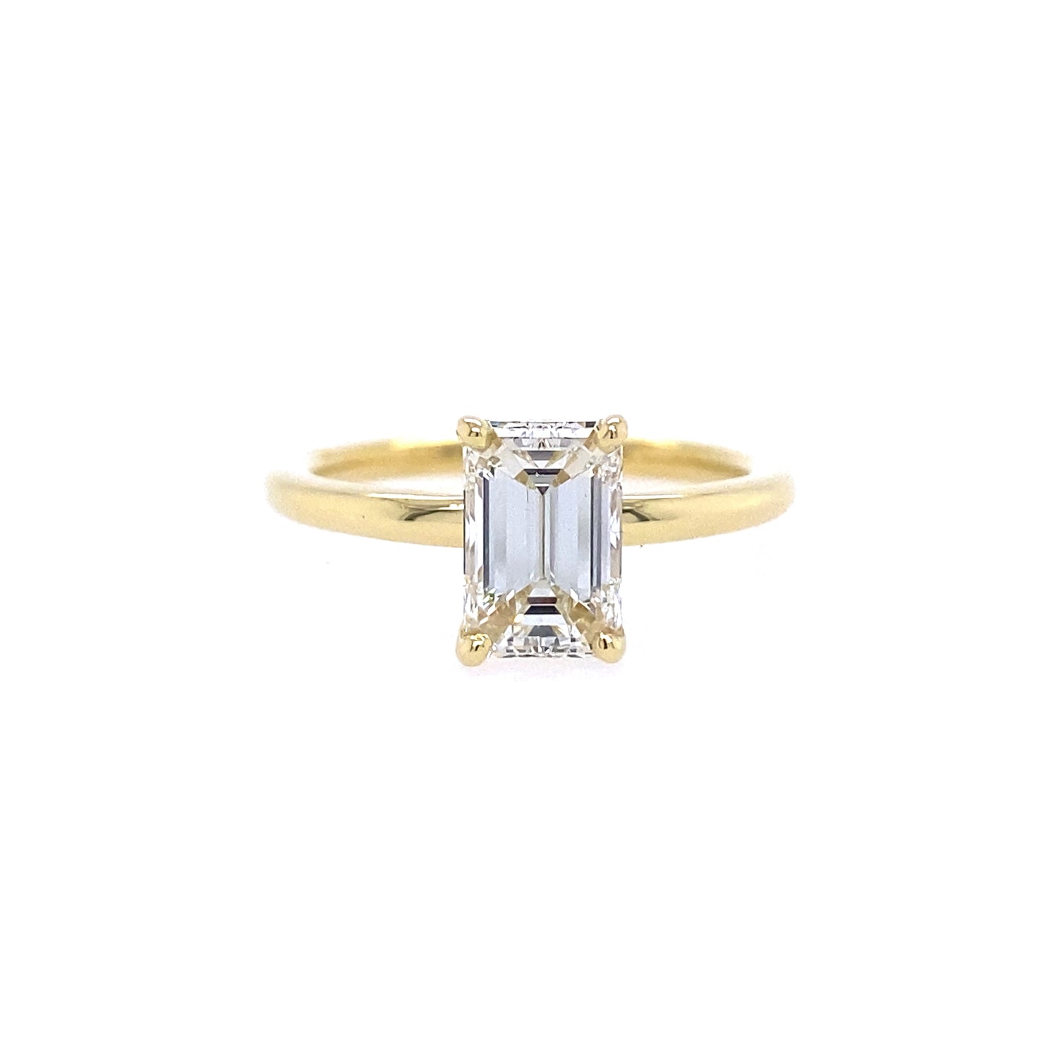 An 18K yellow gold solitaire emerald cut diamond ring 